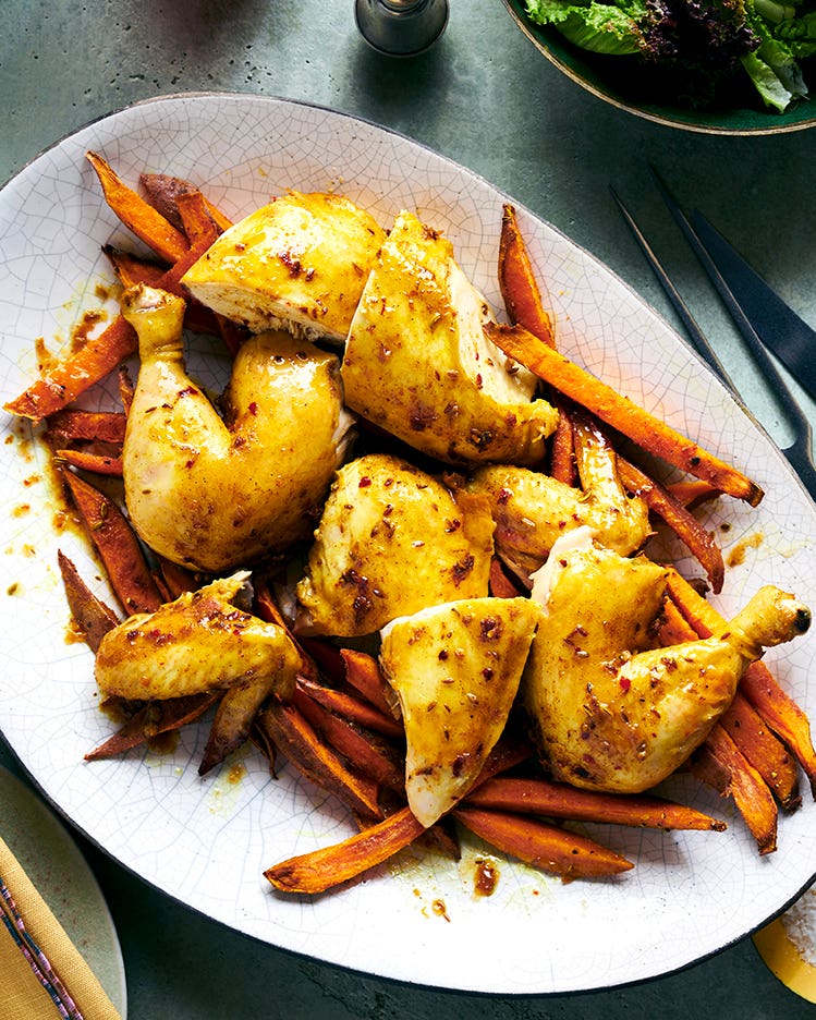 Spicy maple-roasted chicken pieces served with sweet potato oven fries on a large platter.
